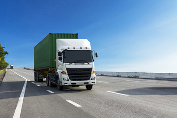 White Truck on highway road with green container, transportation concept.,import,export logistic industrial Transporting Land transport on the asphalt expressway with blue sky