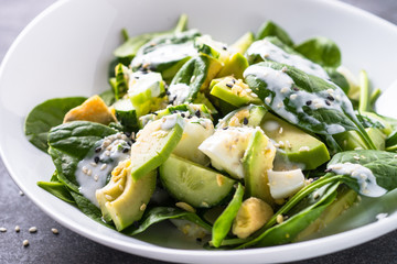 Green salad with avocado, spinach egg and cucumber.