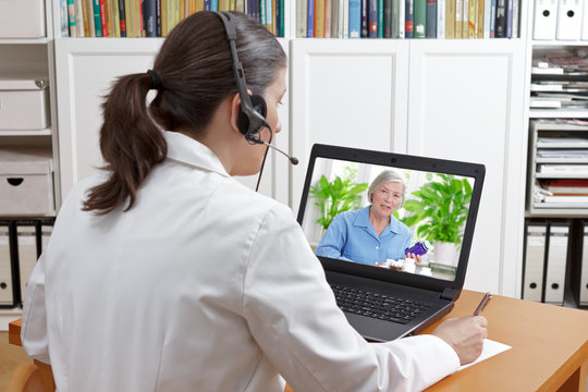 Doctor of geriatrics in her surgery office with headset in front of her laptop during a video call with a senior patient about her prescribed drugs.