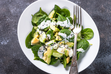 Green salad with avocado, spinach egg and cucumber.