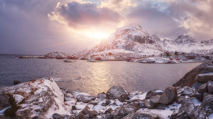 Fototapeta na wymiar Scenery winter landscape in the Norway. Dramatic color sunset sky over the mountains and sea. Panoramic view of small cozy northern village Å, O on the edge of the Lofoten Islands