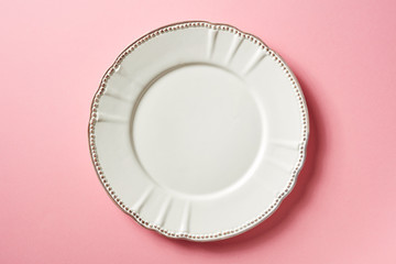 White plate on pink background, from above