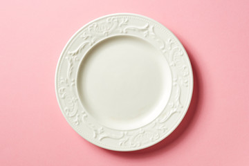 White plate on pink background, from above