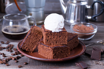 Chocolate cake with ice cream on plate on wood table.