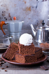 Chocolate cake with ice cream on plate on wood table.