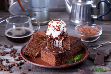Homemade brownies with ice cream on top and chocolate sauce are topping