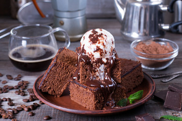 Homemade brownies with ice cream on top and chocolate sauce are topping