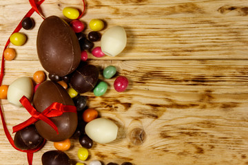 Easter composition with chocolate eggs on wooden background