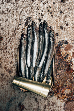 Top view of pile of fish in canister on rustic surface