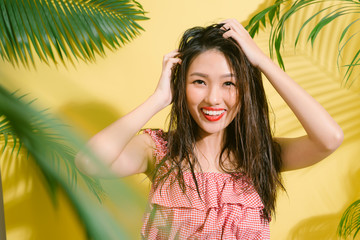 Elegant pretty slim woman in trendy summer outfit posing on a yellow.