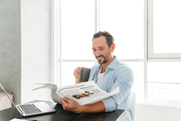 Happy mature man reading newspaper