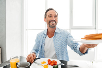 Happy mature man passing a plate
