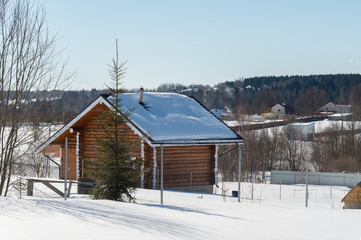 Wooden house in village in sunny winter day