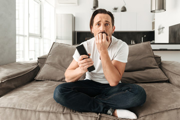 Fototapeta premium Frightened mature man sitting on a sofa