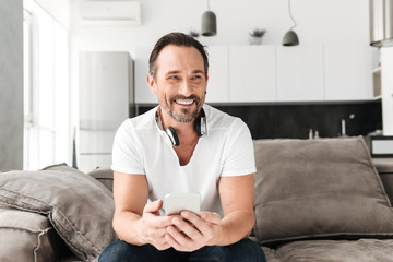 Smiling mature man holding mobile phone