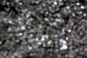 Sparkling spots of Bokeh - a water surface is not in focus, brilliant notes,  the background, metal, blue tint
