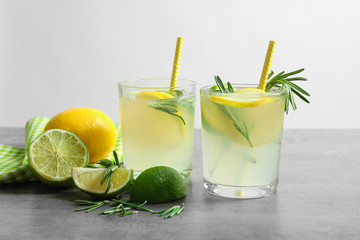Tasty lemonade with rosemary in glasses on table