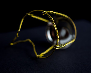 Muselet (wire from the cork) from bottle of champagne. Isolated on black background. Selective focus. Macro