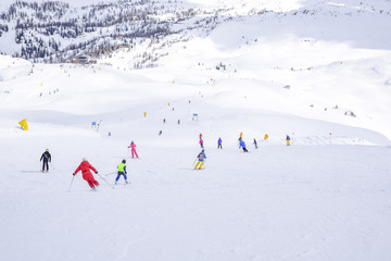 ski slope with skiers in the Alps
