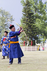 Young man shoots from a sports bow