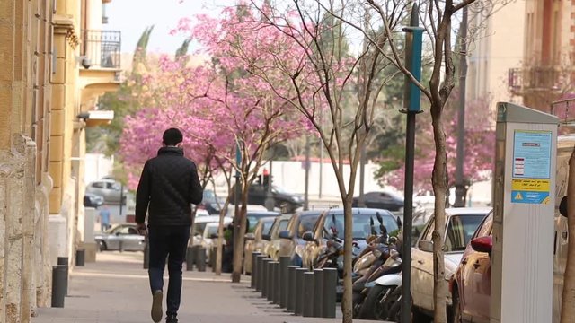 Man walking in beirut streets with flowers