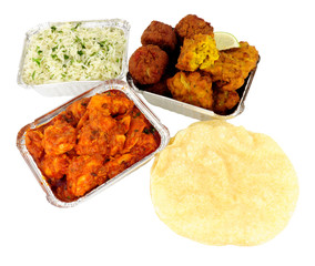 Chicken curry take away meal with rice and poppadoms in foil containers isolated on a white background