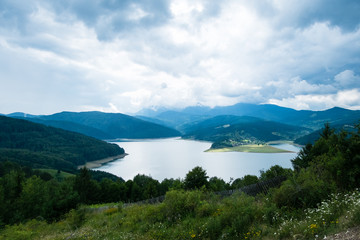 Naklejka na ściany i meble Cloudy landscape view from Lake Bicaz in Romania