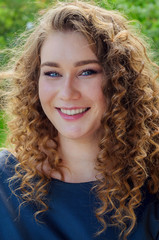 Portrait of a woman with chic curly hair and beautiful light blue eyes.