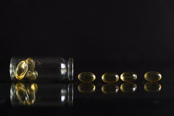 Pill bottle and pills in isolated on black concept pharmacy. With copy space.