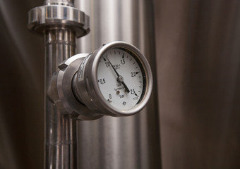 Pressure gauge (manometer) of white metal -  brewing equipment. Close-up, macro.
