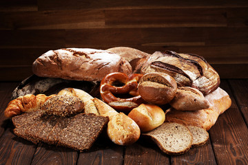 Different kinds of bread and bread rolls on board from above. Kitchen or bakery poster design