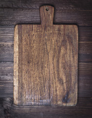 very old brown kitchen cutting board with handle
