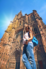 beautiful tourist woman travels through France and stands near the cathedral in Strasbourg