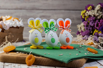 Easter eggs decorated with bunnies on wooden background