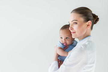beautiful female pediatrician with african american baby isolated on white