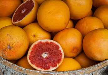 pile of blood oranges in a basket for sale in a food market
