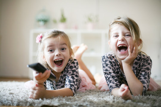 Little girls with remote at home.