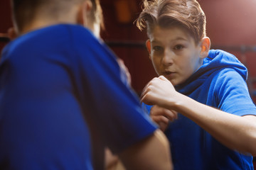 Two young  male boxers train in the ring for a fight
