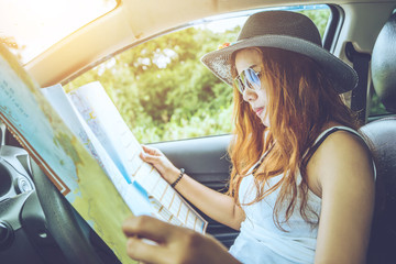 Asian women travel relax in the holiday. Traveling by car park. View map for travel. In the summer