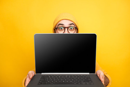 Playful Man Offering Modern Laptop