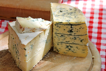Cheese with mold on wooden board.