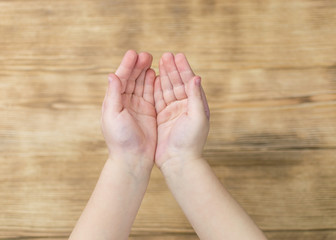 Palm of a young child on a wooden background.
