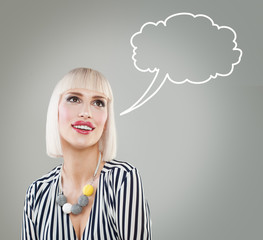 Smiling blonde female model with empty bubble on gray background. Fashion woman portrait