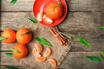 Mandarin oranges with leaves on rustic wood background. Citrus just from the tree.Organic veg food.Winter fruits.
