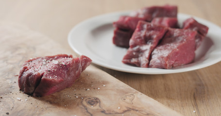 seasoned raw beef fillet for steak on wooden board