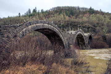 Fototapeta na wymiar round bridges cross a river in zagorohoria greece