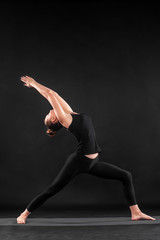 Acroyoga. Young woman practicing acro yoga on mat in studio. Hatha yoga.