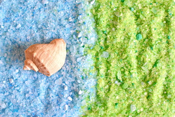 Seashell on blue soluble crystals green and blue sea salt with foam for bath tube for aroma therapy and spa salon relax treatment. Texture. Background