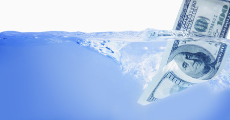 Money concept showing US Dollar sinking in water as a symbol of global economic crisis