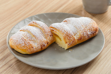 Fresh baked puff bun with custard on gray plate
